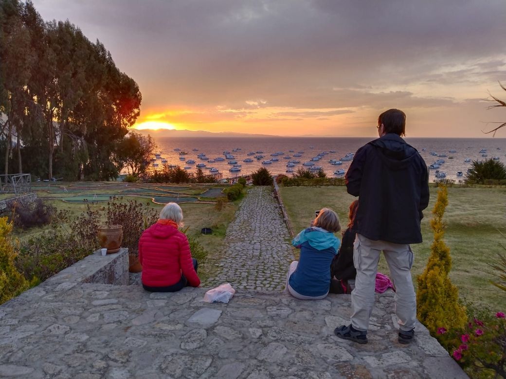 Travellers watching the sun set over Lake Titicaca