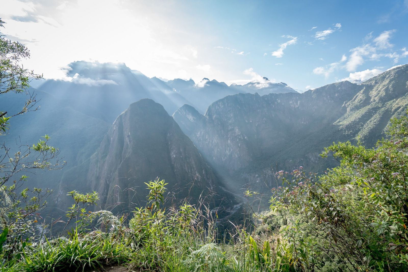 Morning light over the peaks above Machu Picchu, the citadel small below them